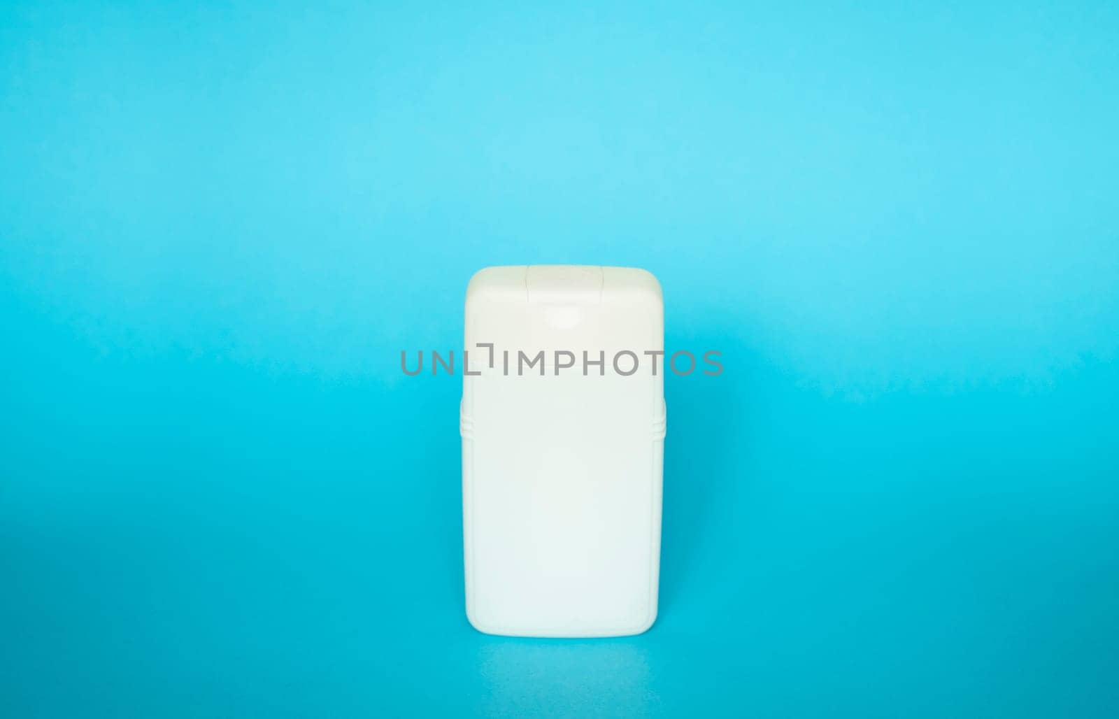 White square bottle for liquid soap, shampoo, gel on blue background