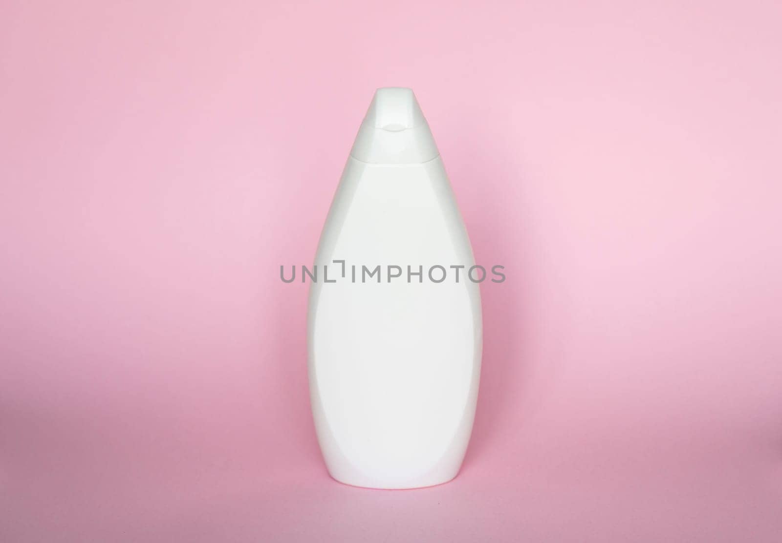 White liquid container for gel, lotion, cream, shampoo. Cosmetic plastic bottle on pink background. Cosmetic packaging mockup with copy space. by vovsht