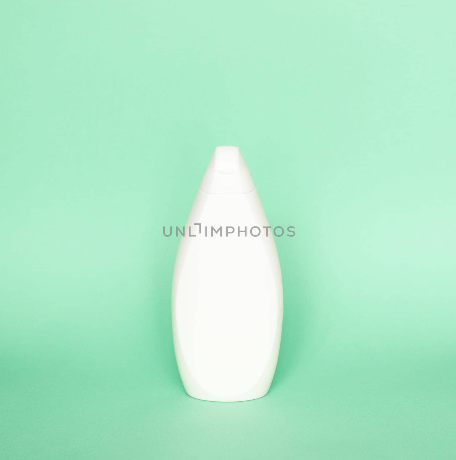 Blank shampoo bottle or shower gel on pastel green background. Container, beauty product and body care cosmetics