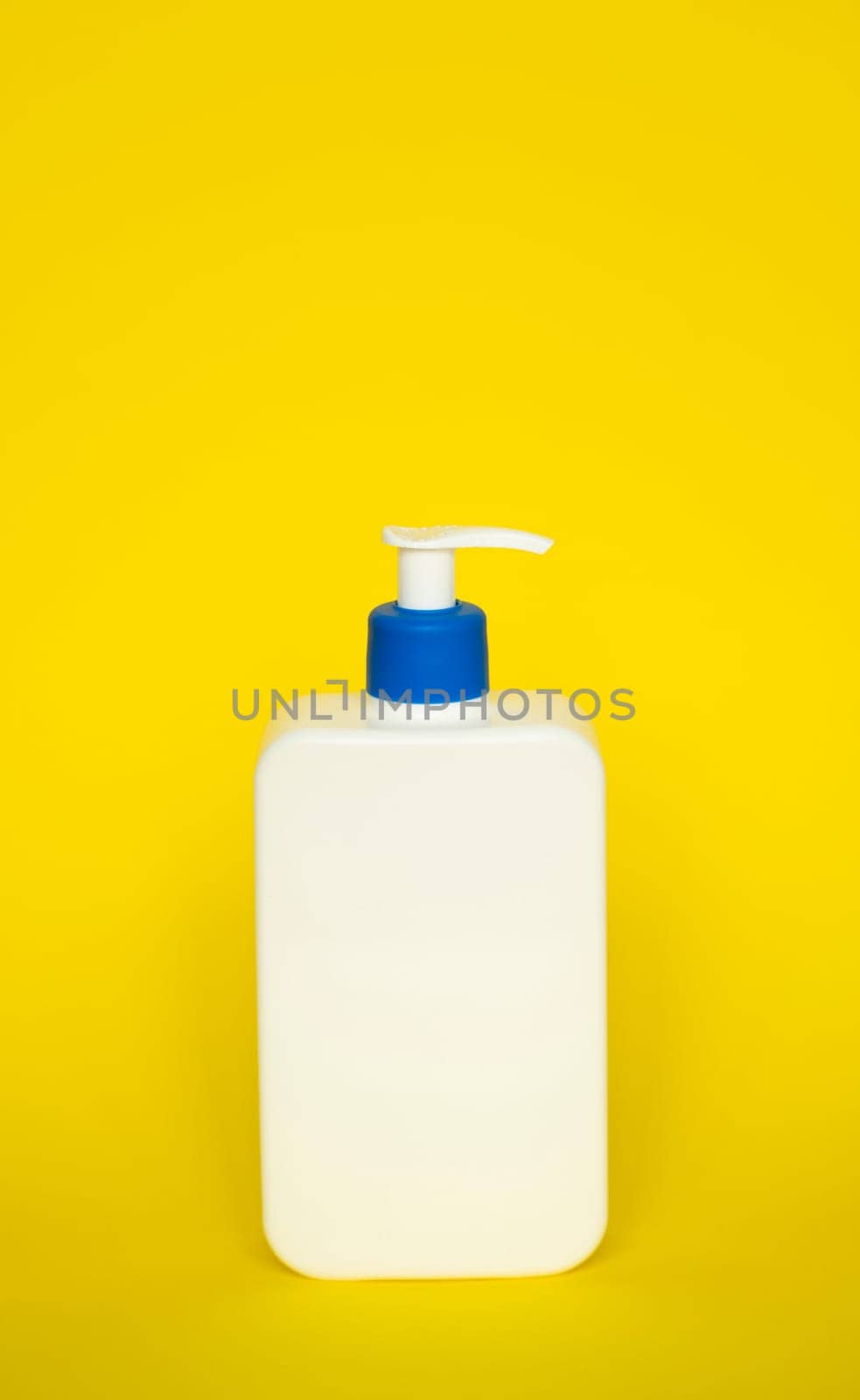 Square white blank unbranded cosmetic plastic bottle with dispenser pump for shampoo, gel, lotion, cream, bath foam on yellow background. by vovsht