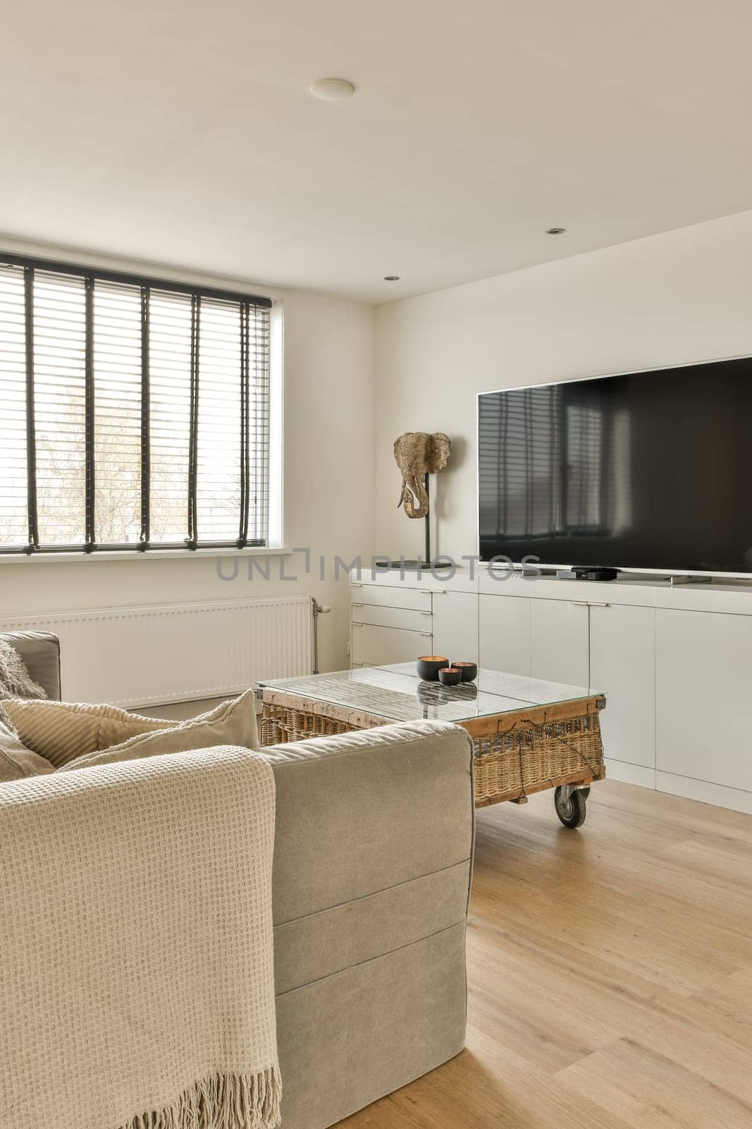 a living room with couches and a flat screen tv on the wall in front of the sofa is white