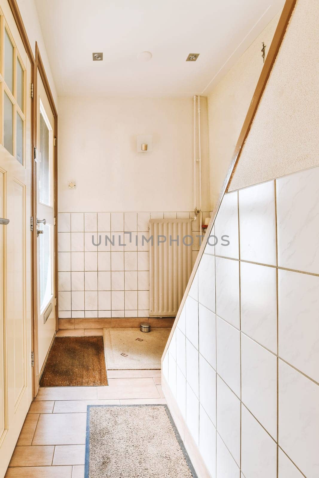 a bathroom with white tiles on the walls and flooring in front of the bathtub is shown to the right