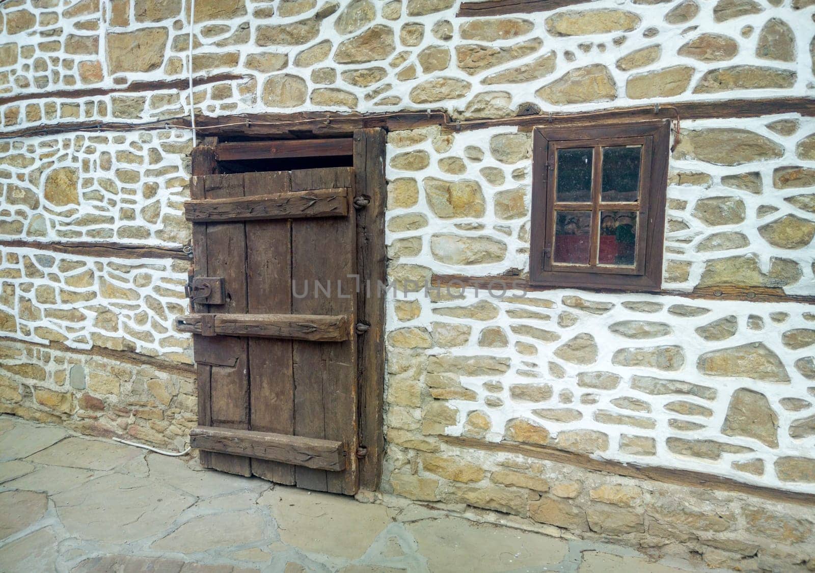 Traditional wooden old door and window at a stone house in Bulgaria