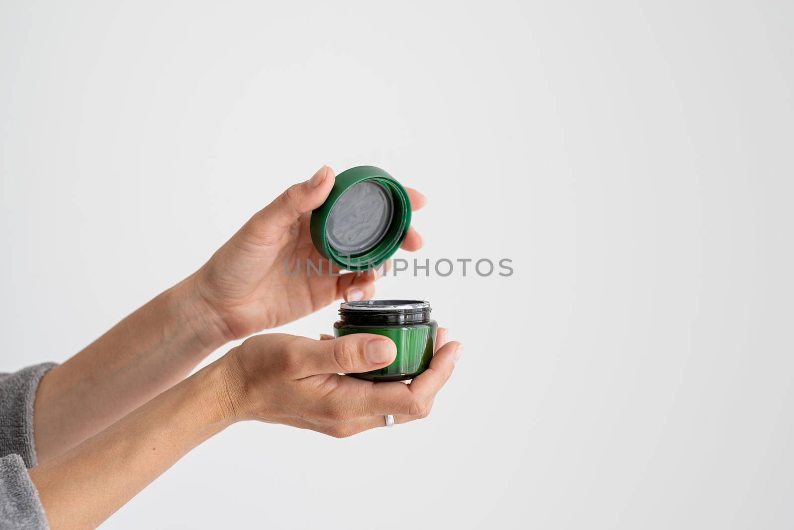 Young woman holding jar with face mask by Desperada