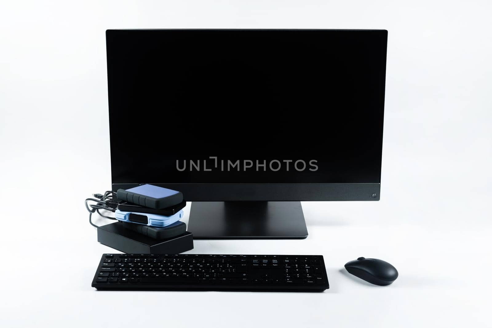 Multiple external hard drives connected to a monoblock on a white background.Computer with hard drive.