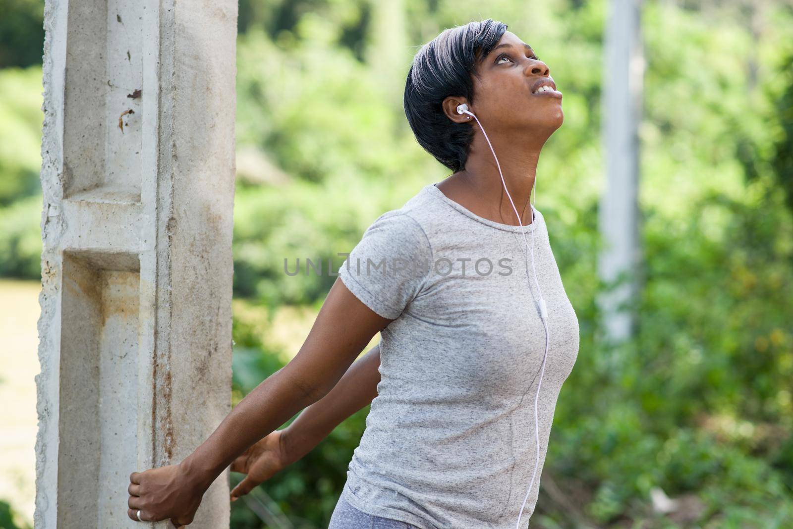 Sports and hobbies. Sporty smiling woman doing outdoor stretching in the park. Woman exercising in fresh air.