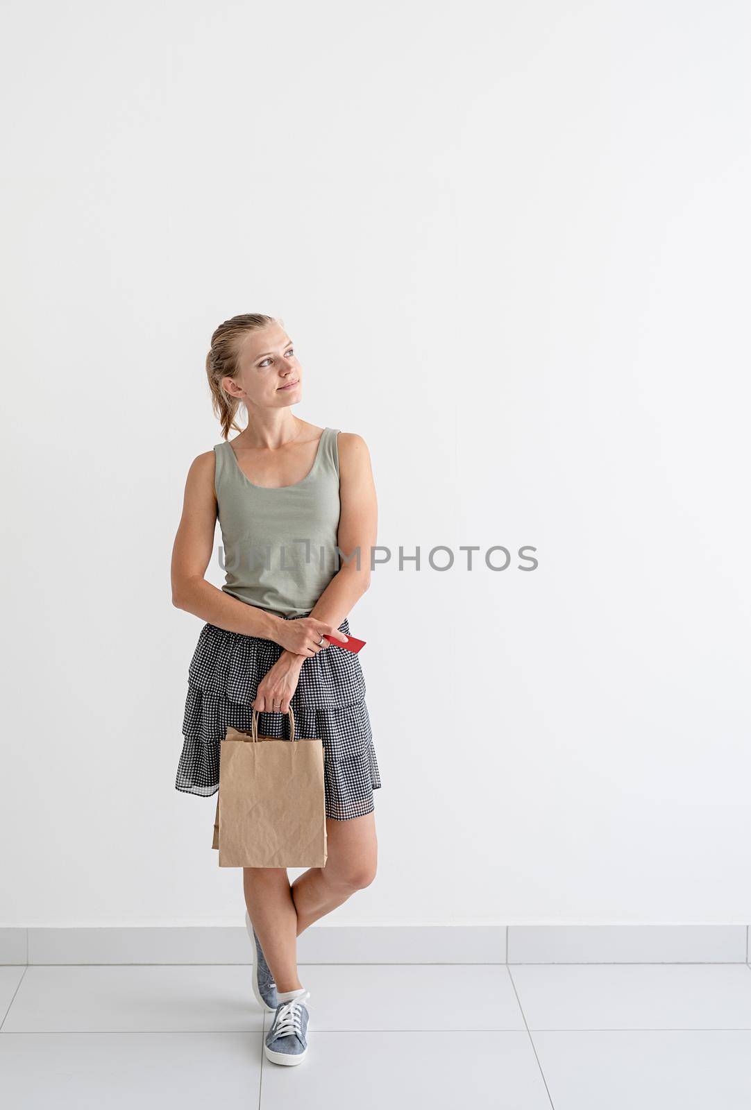 Online shopping concept. Young smiling woman holding eco friendly shopping bags and creadit card