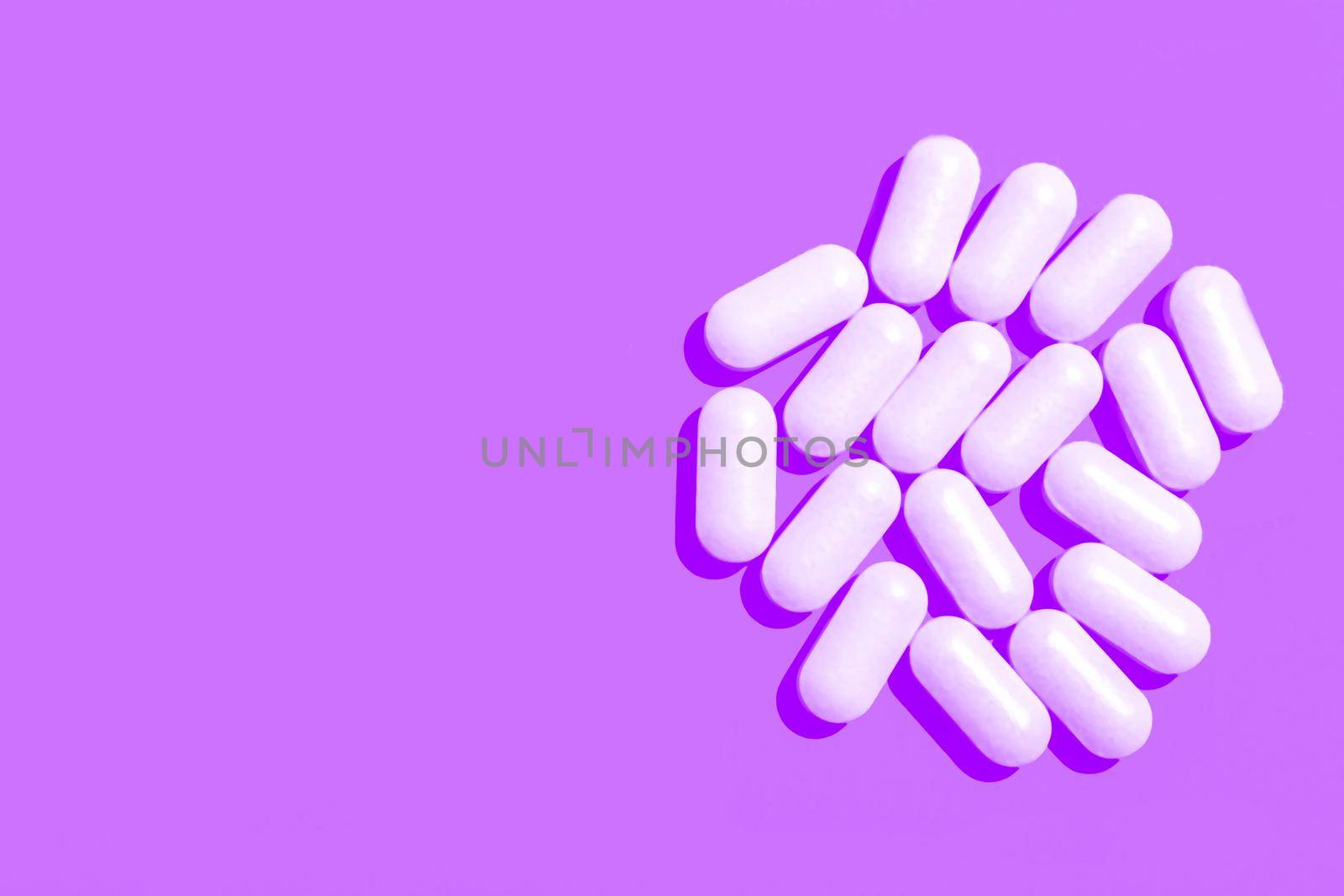 White tablets capsules on purple background. Copy space. by Essffes