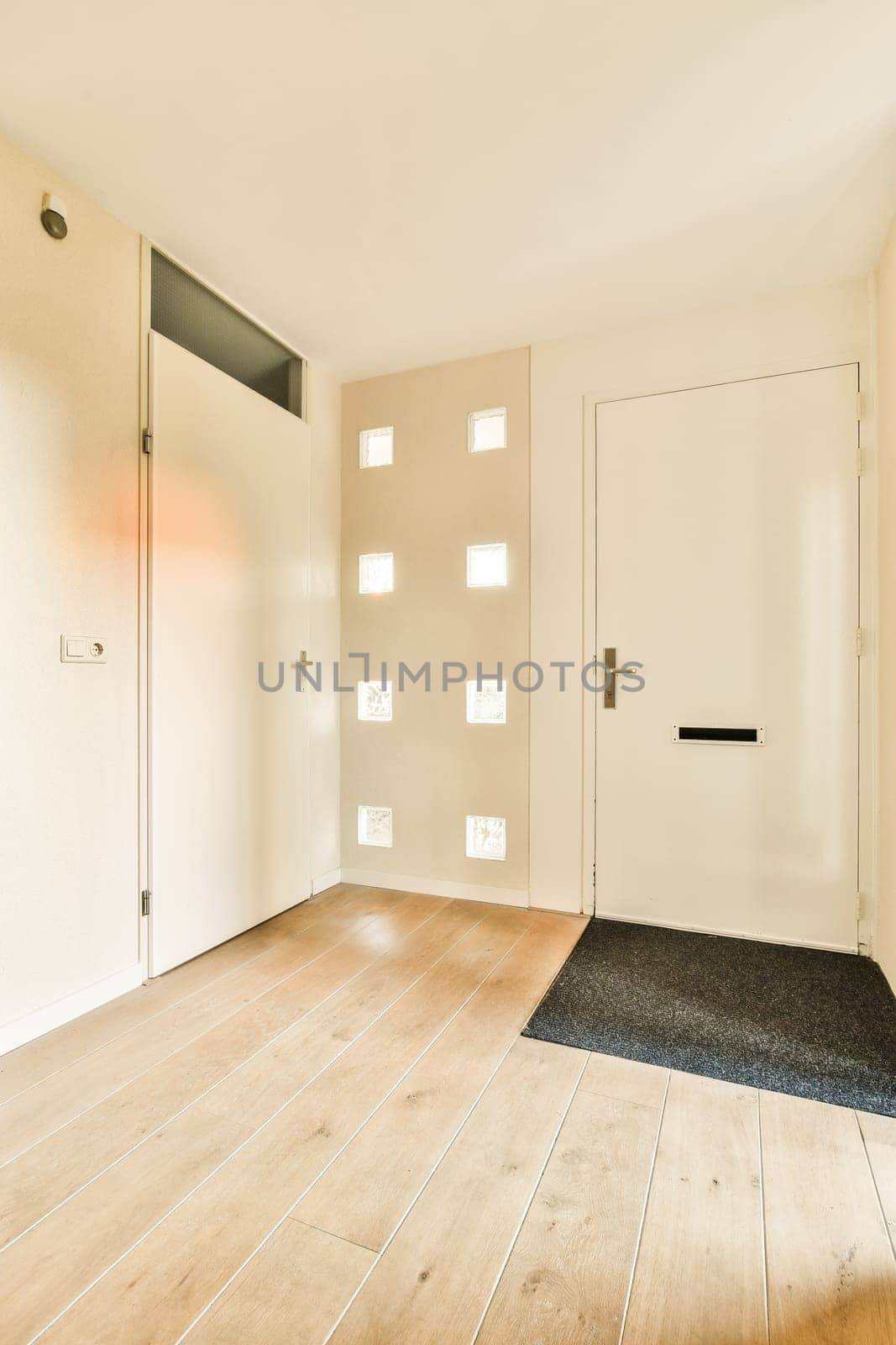 an empty living room with wood flooring and white walls, there is no one in the room to be seen