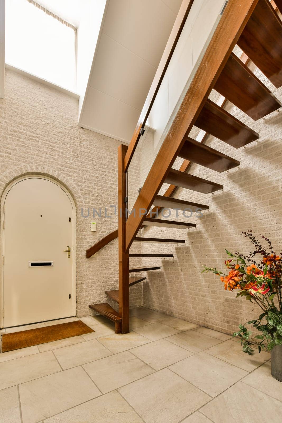 a house with some flowers in the entry way and stairs leading up to the upper level, which is very well lit