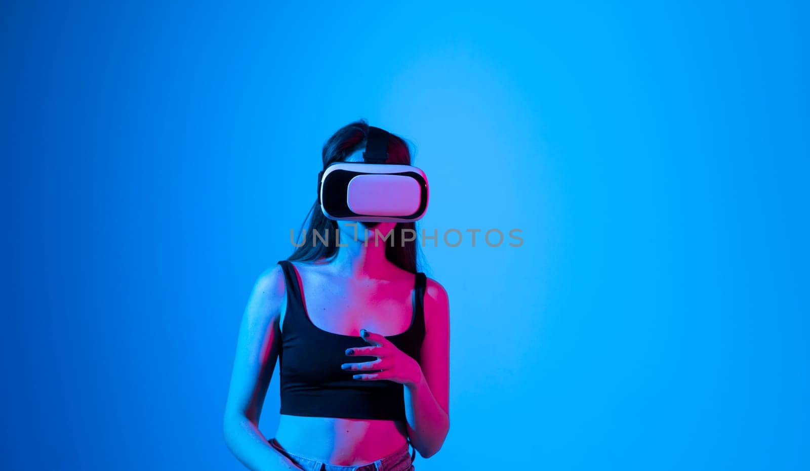 Brunette woman wearing virtual vr goggles. Young famale in a black top wearing virtual reality headset. VR concept