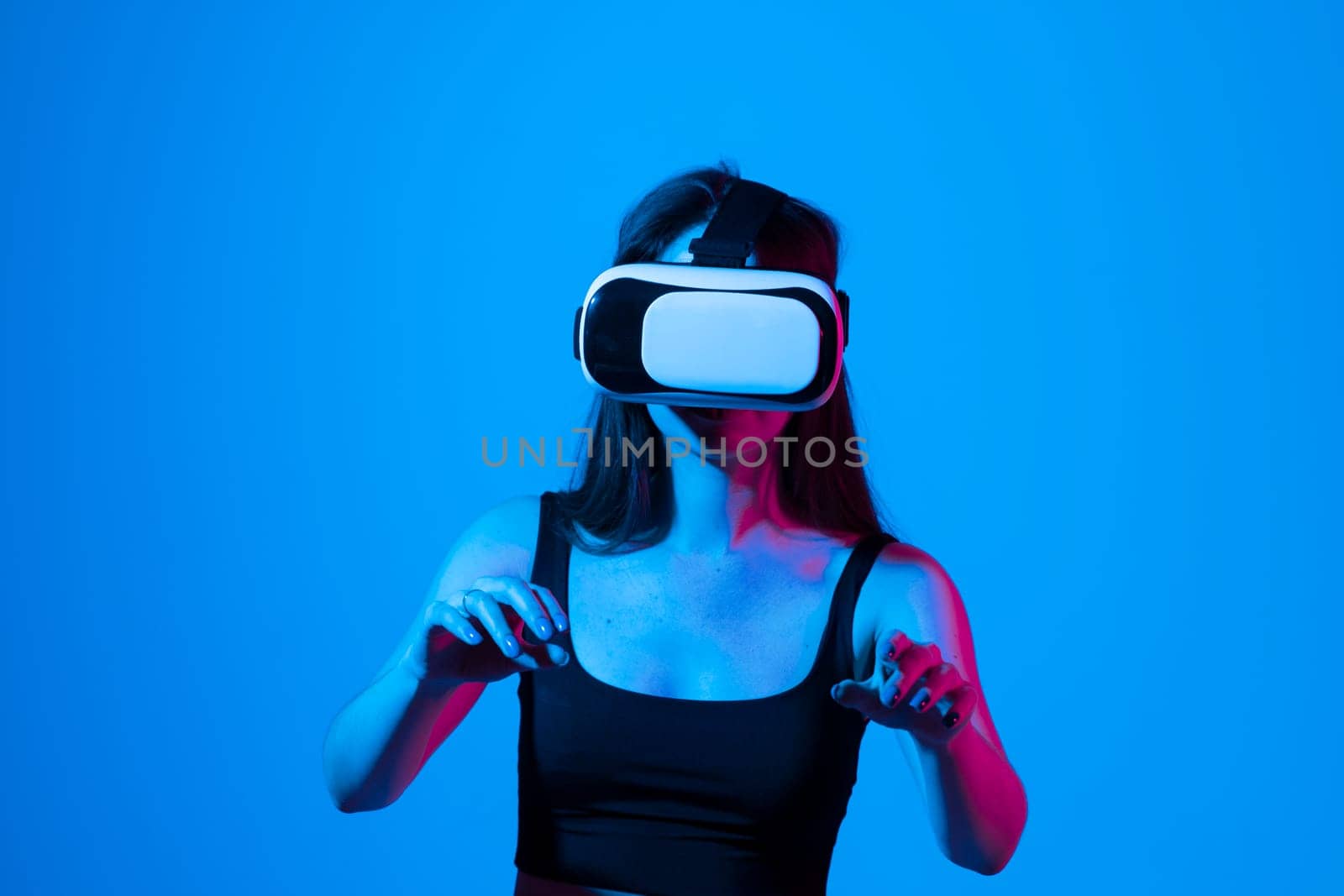 Brunette woman in a black top wearing virtual reality goggles in modern coworking studio. by vovsht