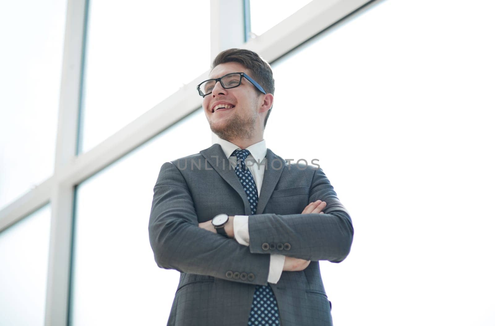 Portrait of a young businessman wearing glasses and standing in office