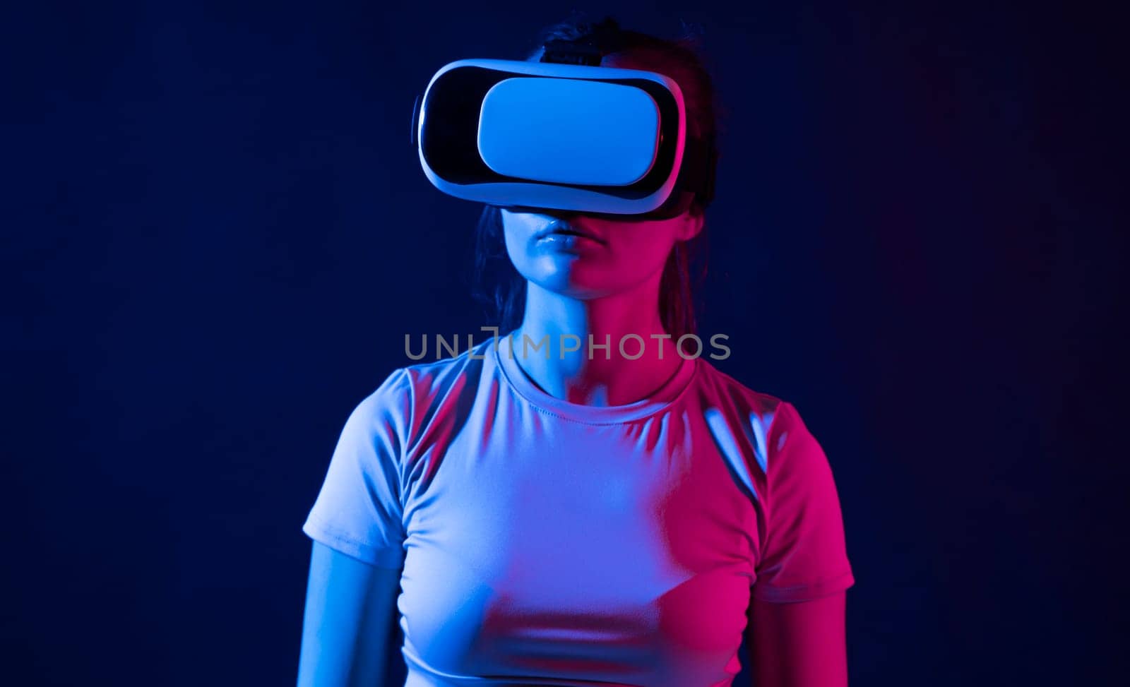 Brunette woman using virtual reality glasses indoor. Girl having fun with innovated vr googles technology