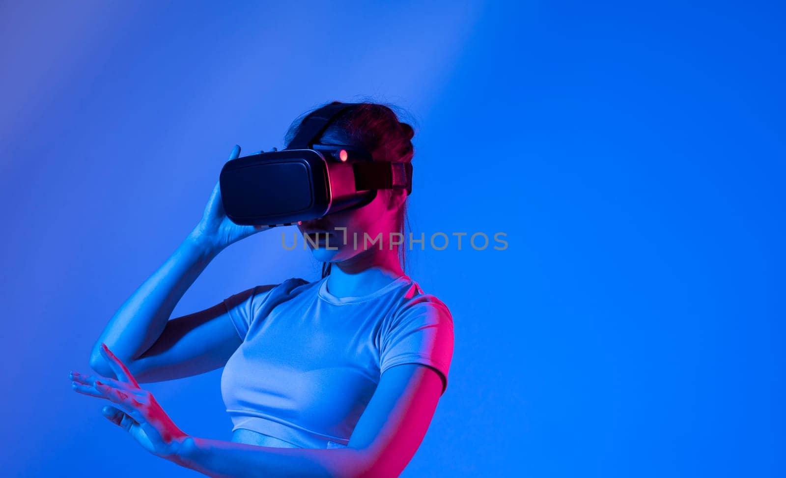 Young cute woman wearing a virtual reality googles and playing a video game in virtual world with a friends. by vovsht