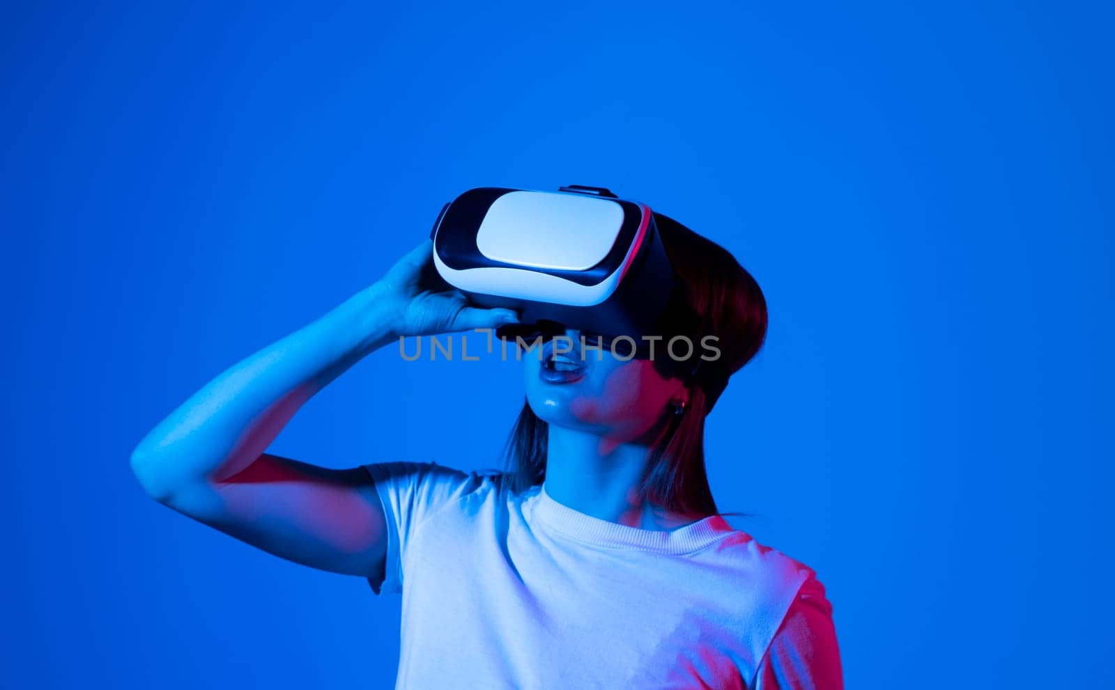 Young woman in virtual reality VR glasses playing a video games. by vovsht