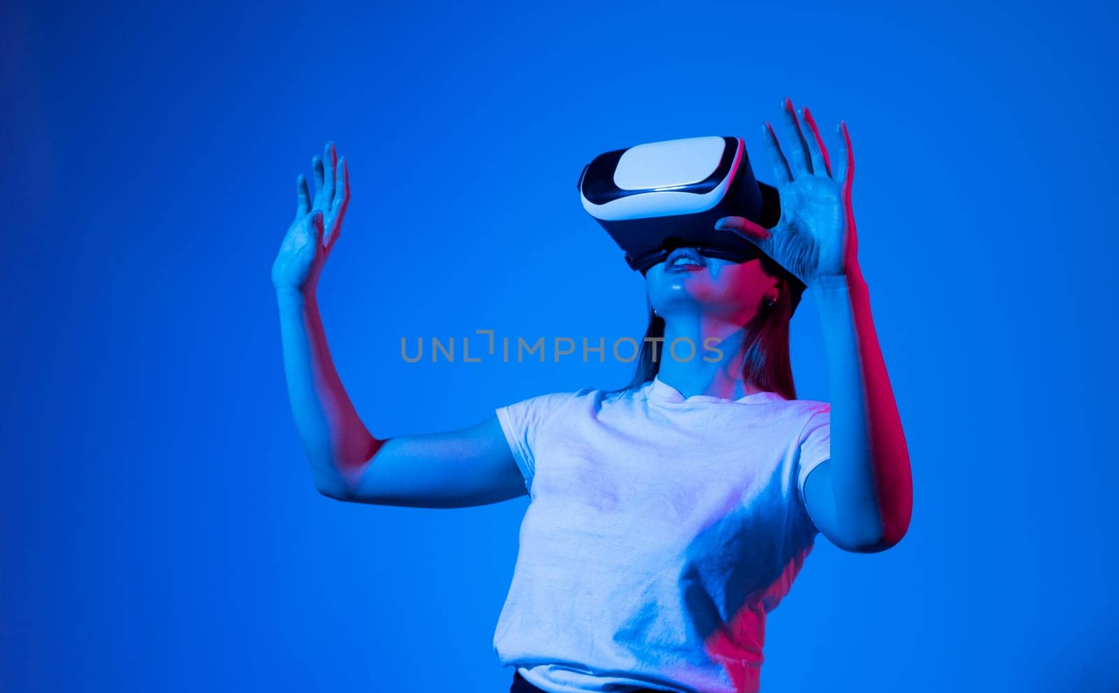 Brunette woman in virtual reality headset playing a video games with a friend's. Future gaming concept