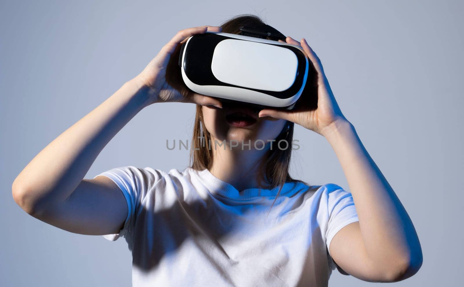 VR technologies. Confident young woman in virtual reality headset pointing in the air. by vovsht