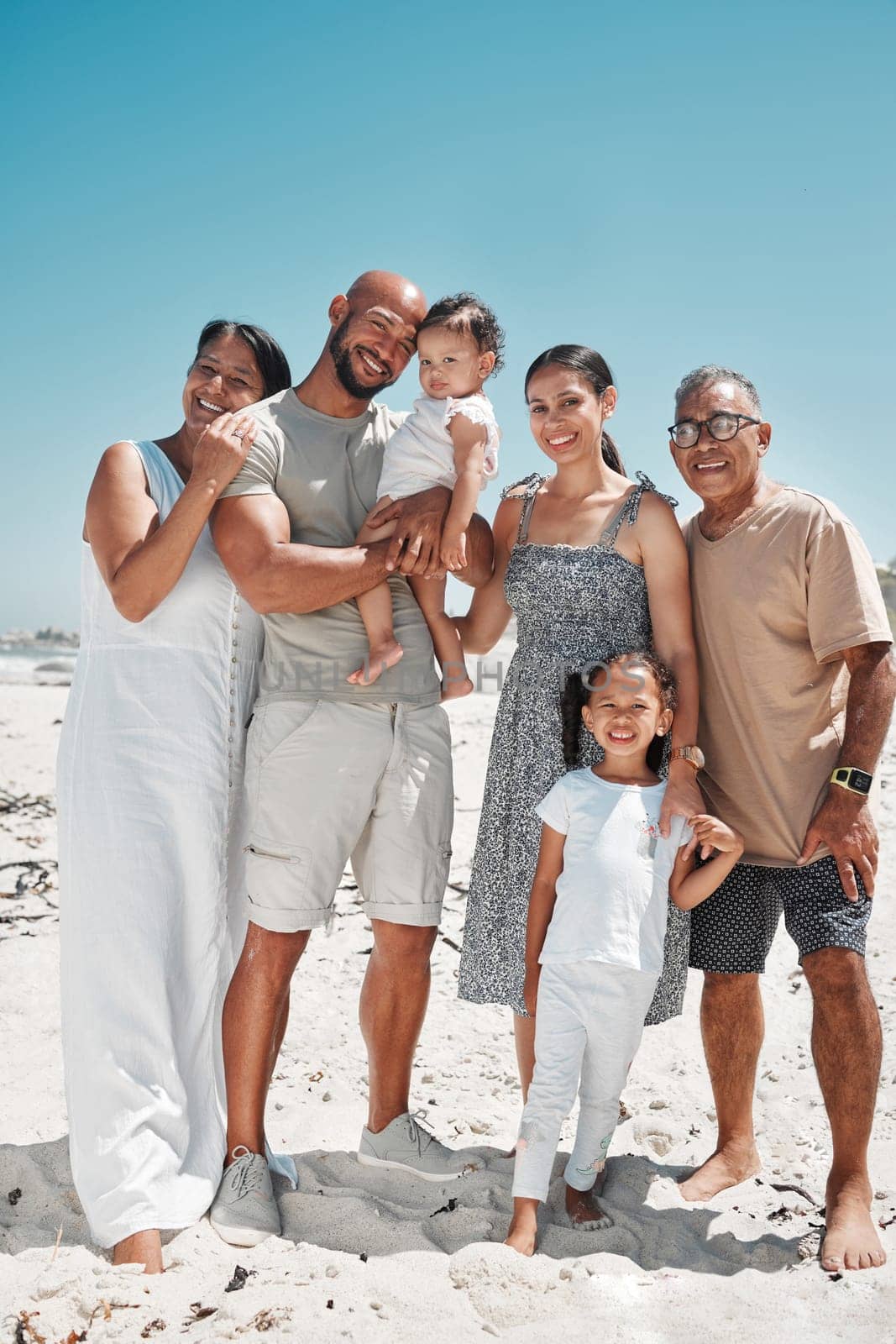 Big family, portrait and smile on beach holiday, vacation or Mexico summer trip. Generations, parents and children on sandy, sea or ocean shore having fun, bonding and spending quality time together