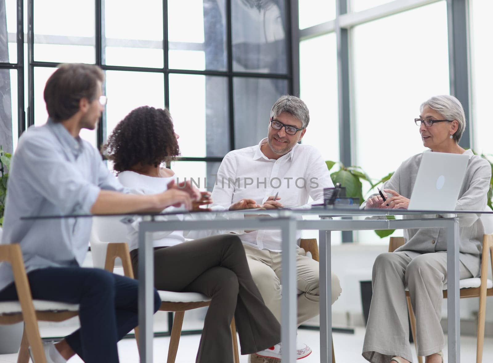 Serious team of professionals, business people negotiating in modern boardroom, discuss project