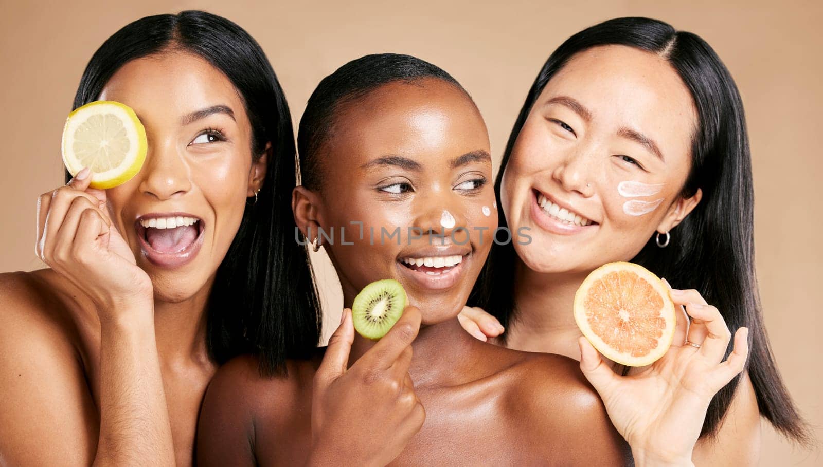 Face, fruits and women in portrait with cream for facial care, beauty and natural cosmetics isolated on studio background. Sunscreen, vegan and different skin with skincare, moisturizer and playful by YuriArcurs