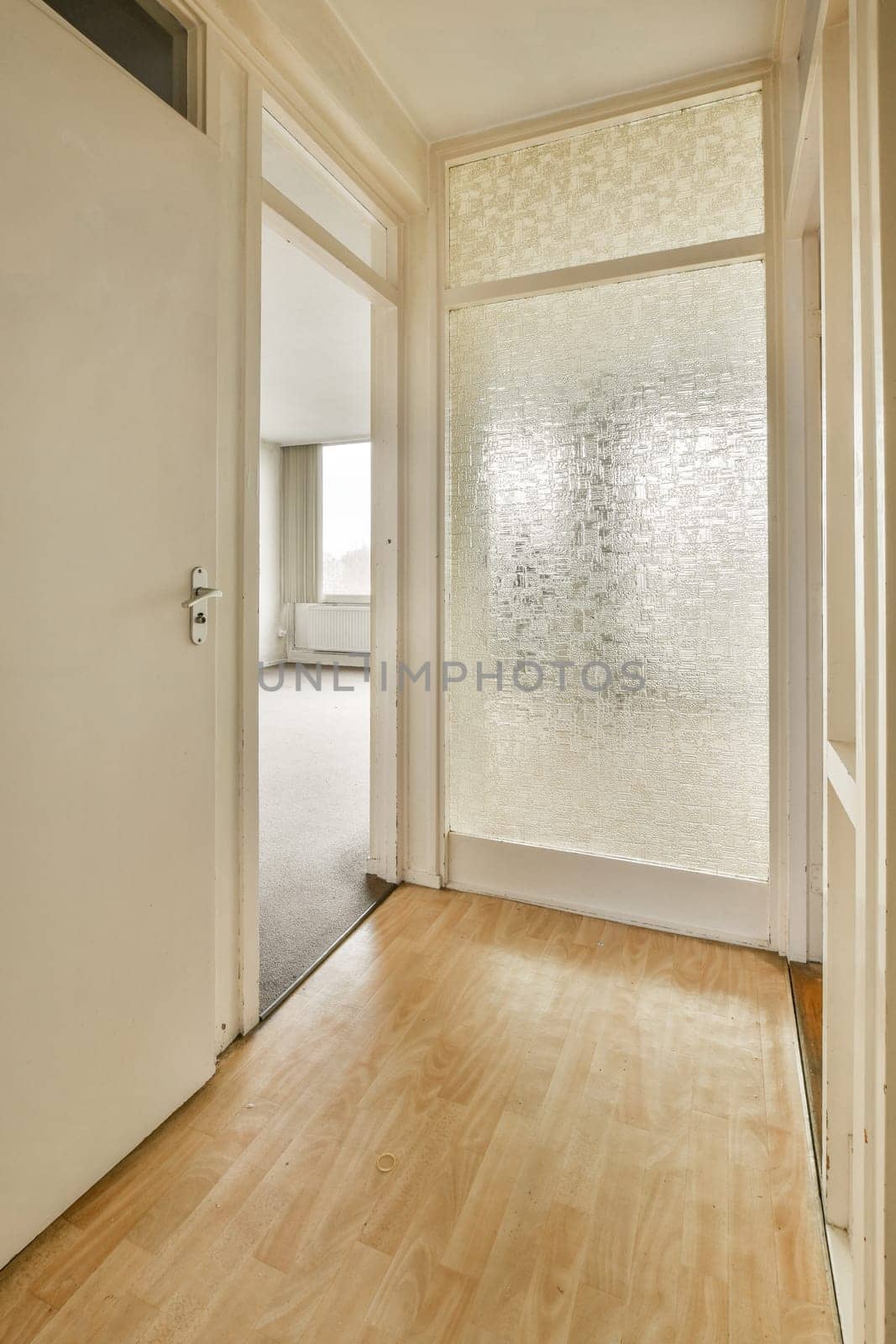 a glass door in a room with a wood floor by casamedia