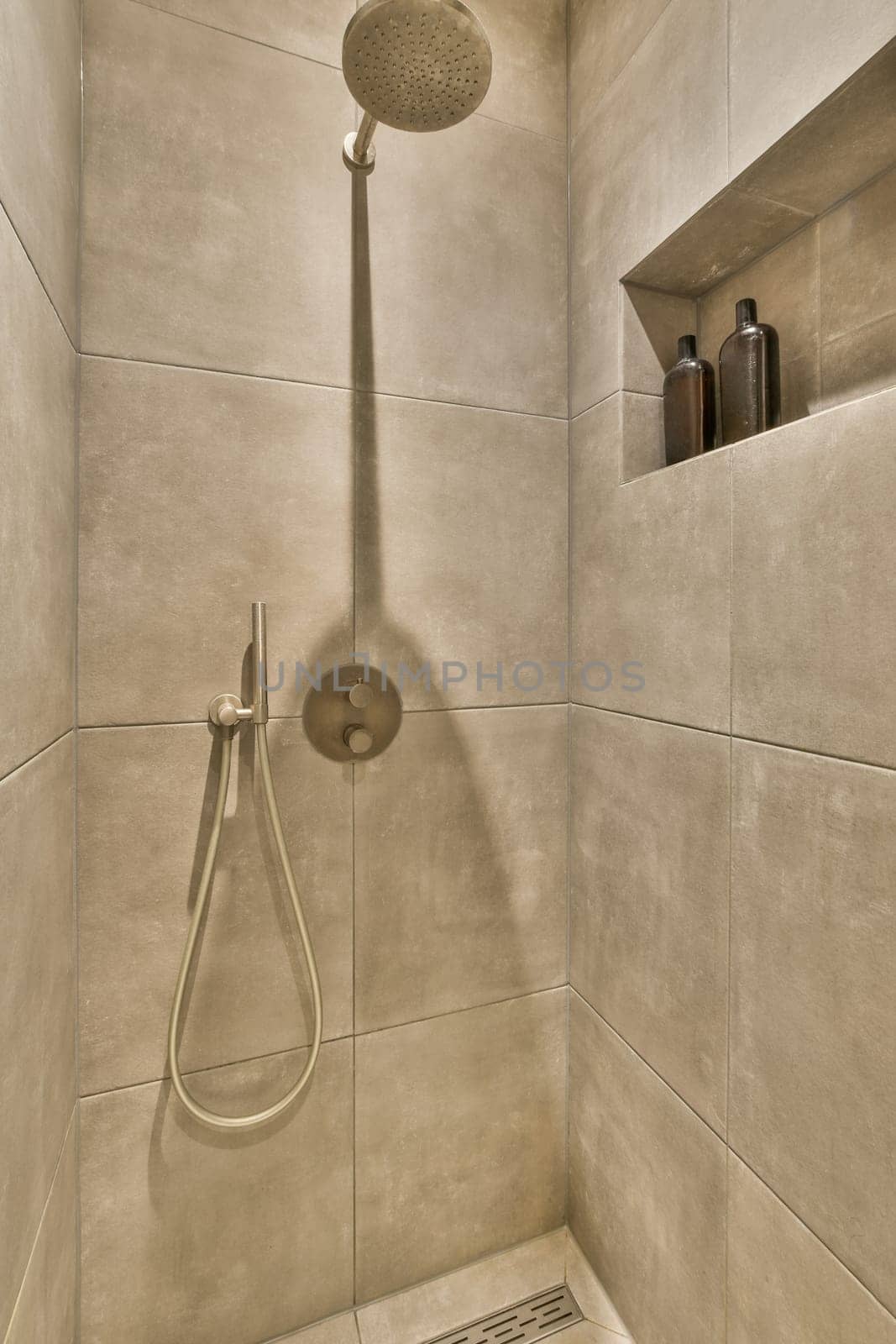 a shower in a tiled bathroom with a shower by casamedia