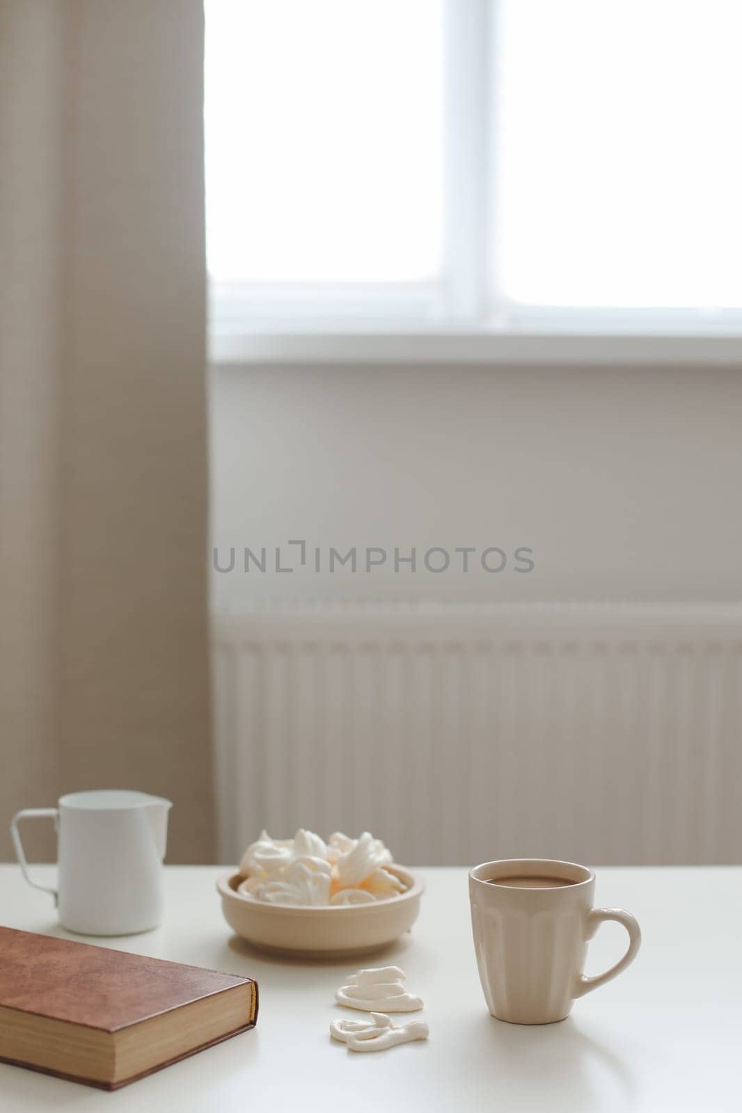 Toned in beige colors image, cup of dark coffee, white background in a cozy room