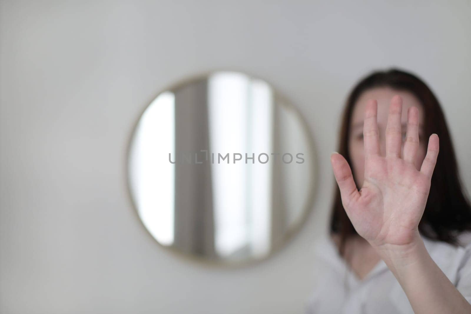 young woman looking in the mirror. Mental health problems in self-isolation at home. Reflection in mirror. Depression, anxiety, phobia, suicide and mental health concept.