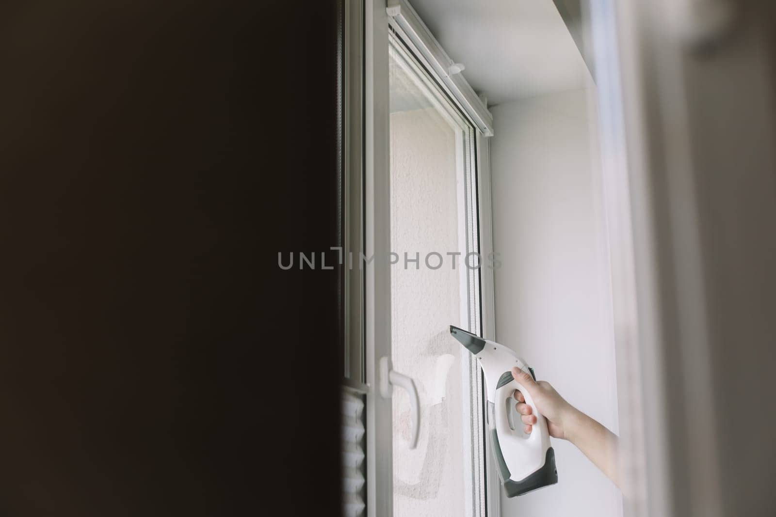 Man washing and cleaning window at home. Housework and housekeeping, home hygiene by paralisart