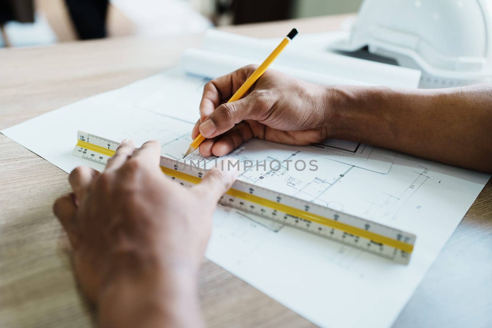 Engineers are designing house structures and architectural using blueprints, rulers, pencils, dividers and building models to work.