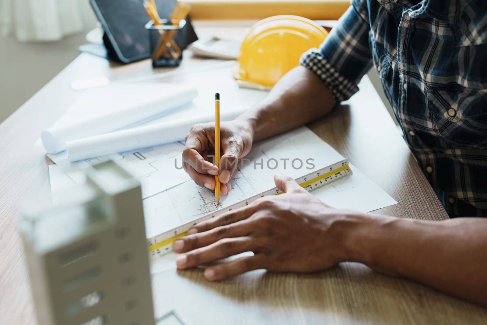 Engineers are designing house structures and architectural using blueprints, rulers, pencils, dividers and building models to work.