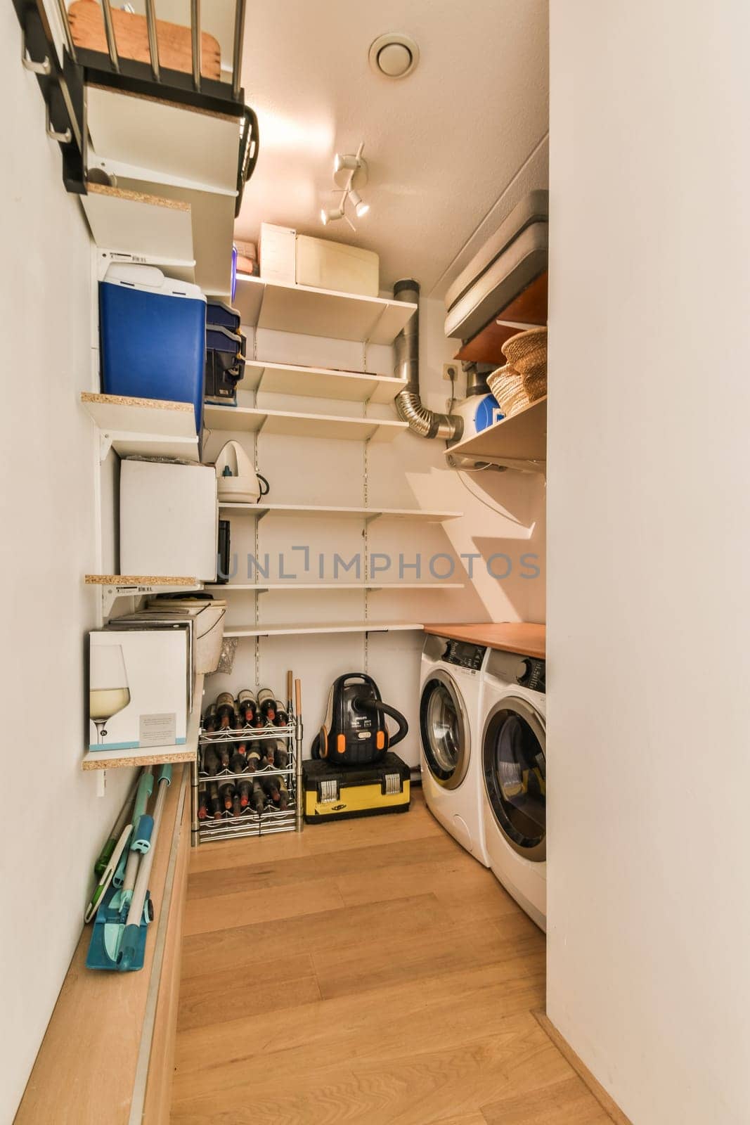 the inside of a laundry room with wood flooring and white walls that have been painted to look like wallpapers