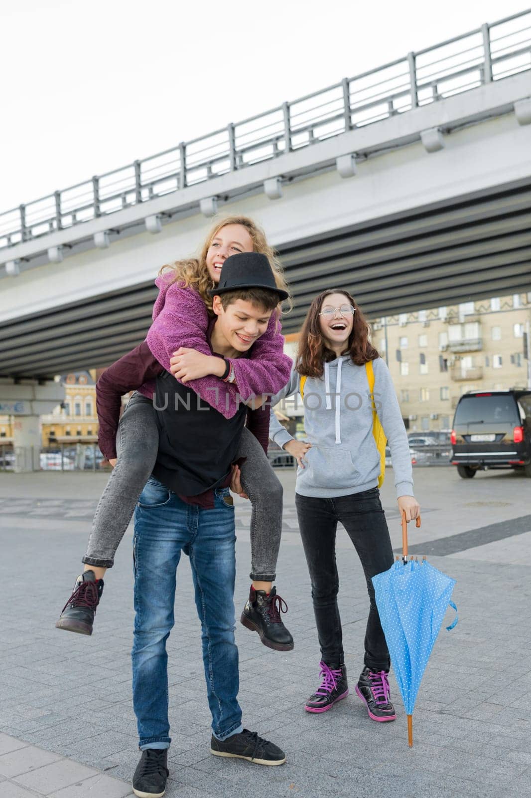 Teens boy and two girls talking and having fun outdoor, lifestyle of teenagers in the city