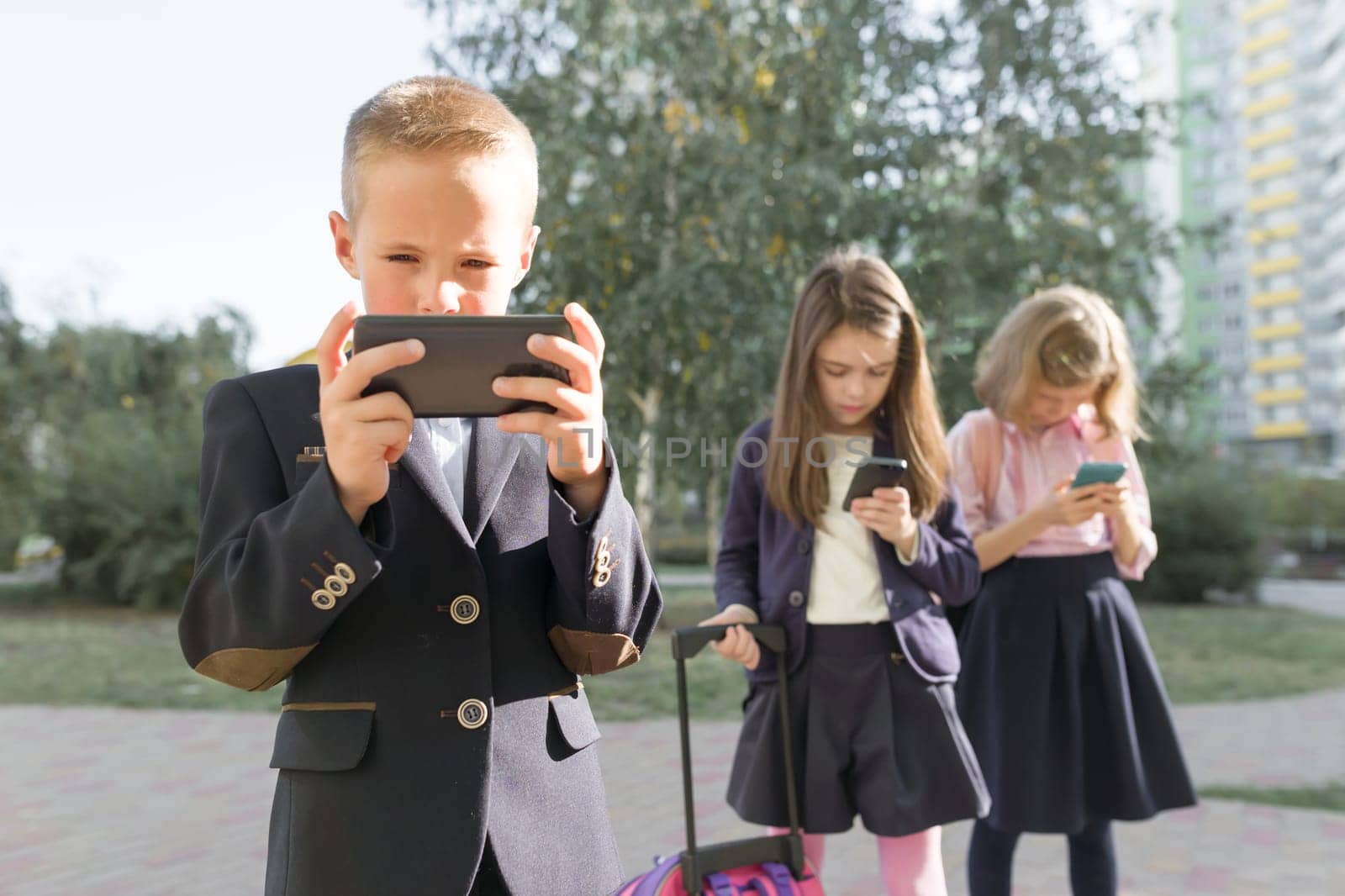 Group of schoolchildren 7, 8 years old with mobile phones by VH-studio