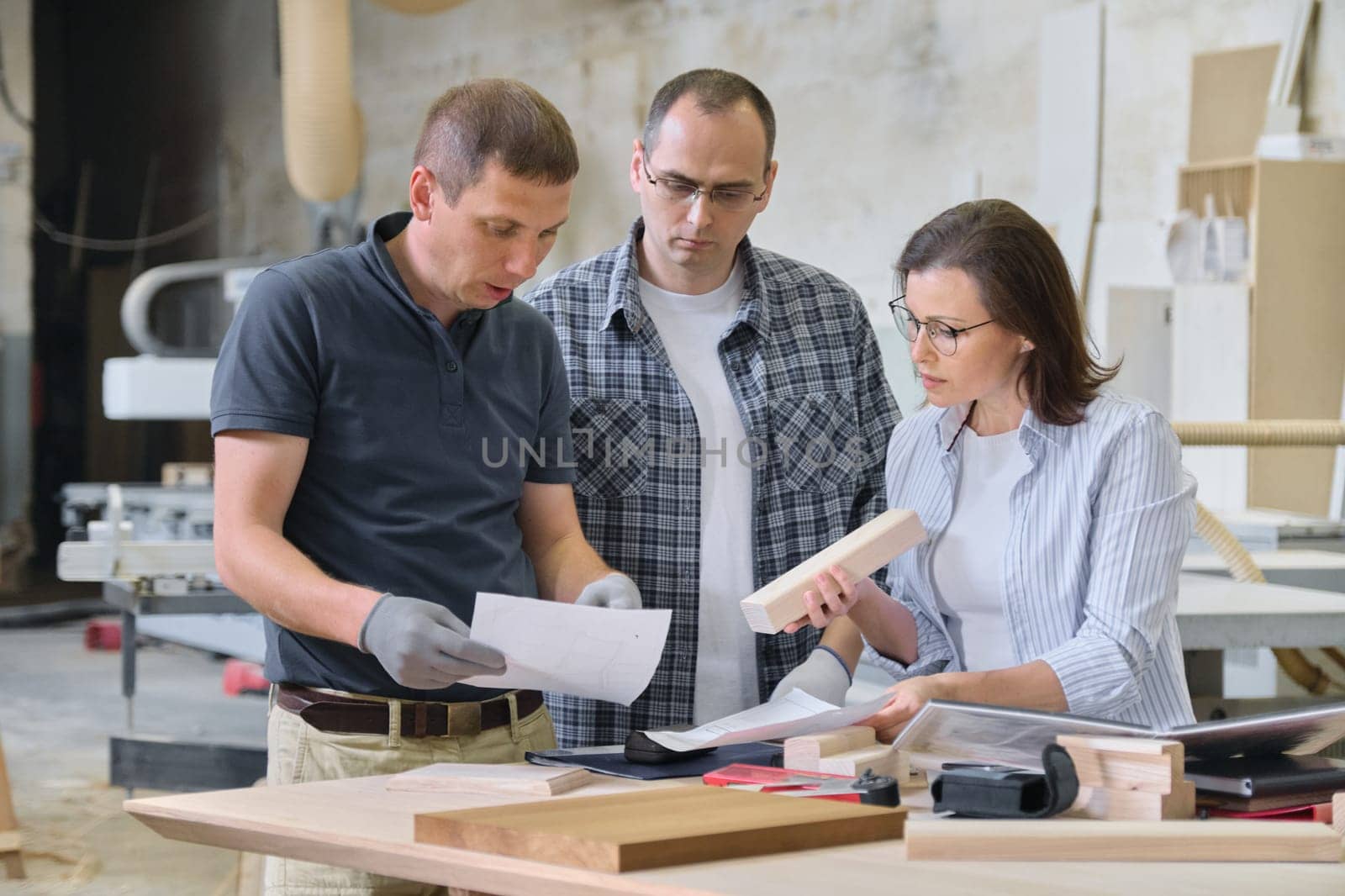 Team of woodworking workshop workers are discussing. by VH-studio
