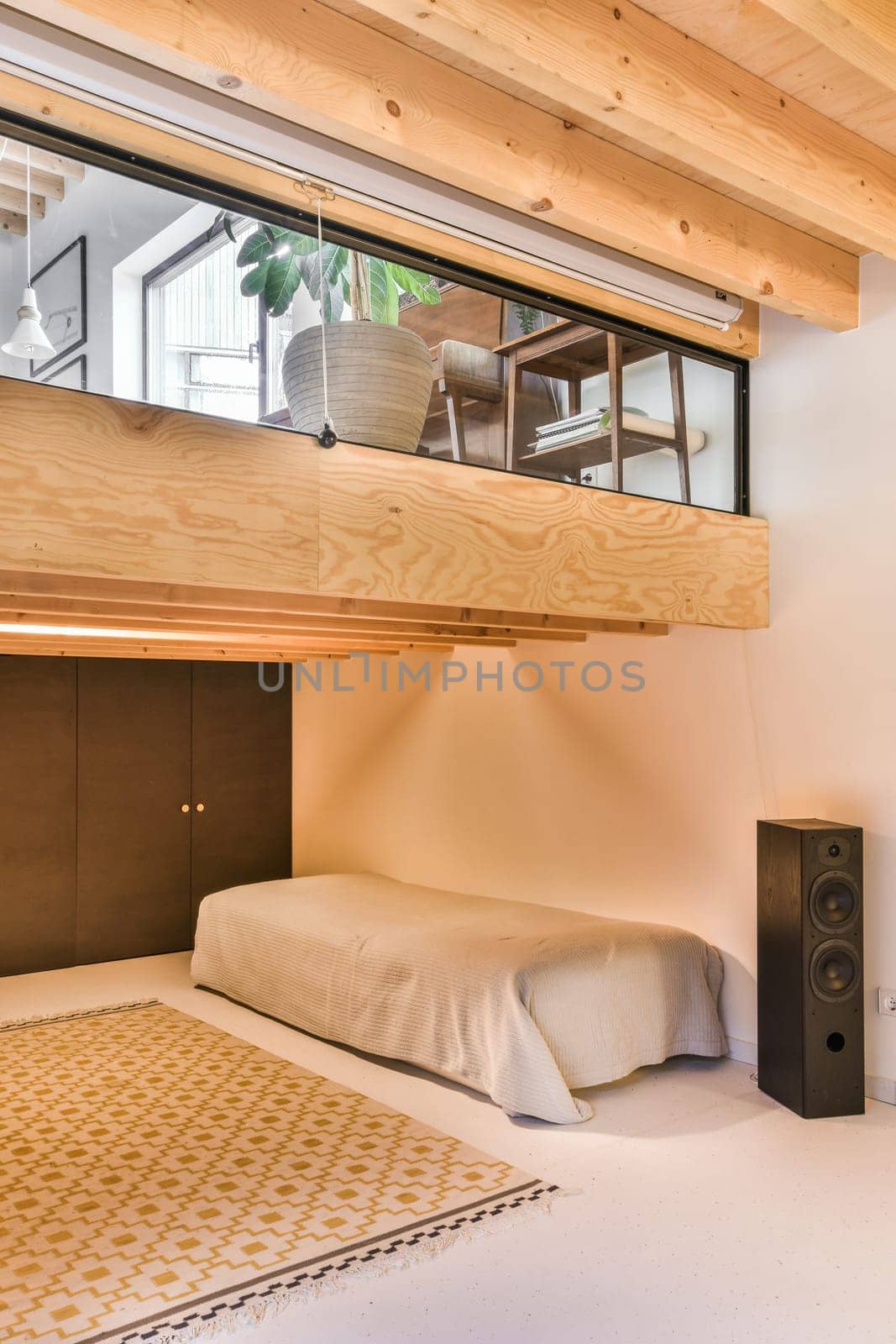 a room with a bed, speakers and a mirror on the wall above it that is made out of wood