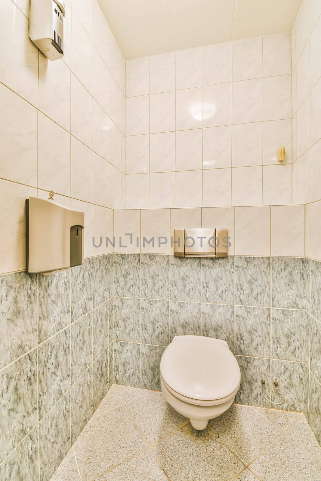 a white toilet in a bathroom with tile on the walls and flooring around it's edge, as seen from above