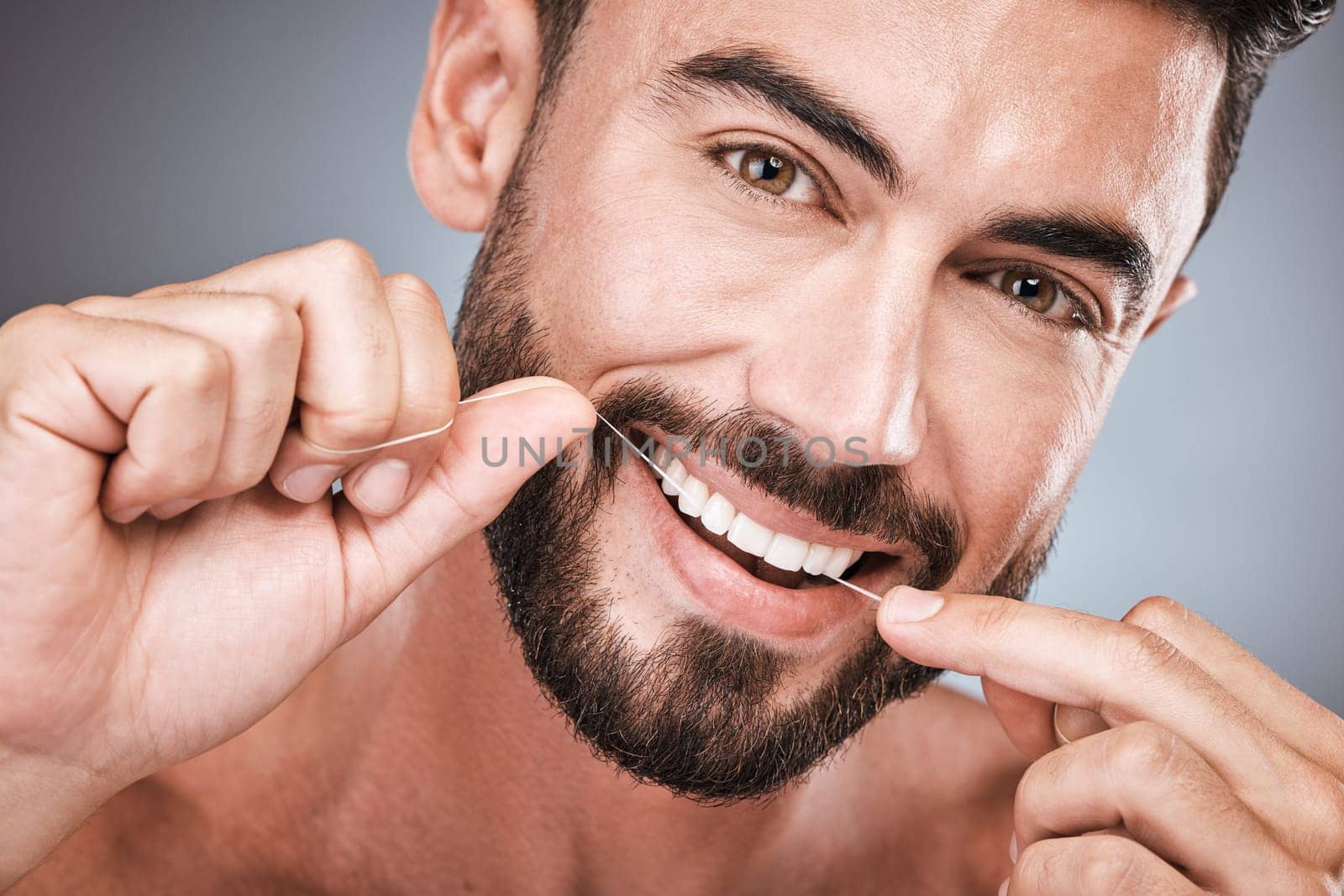 Floss, cleaning teeth and portrait of man in studio for beauty, healthy body and hygiene on background. Male model, tooth flossing and mouth for facial smile, fresh breath and happy dental wellness.