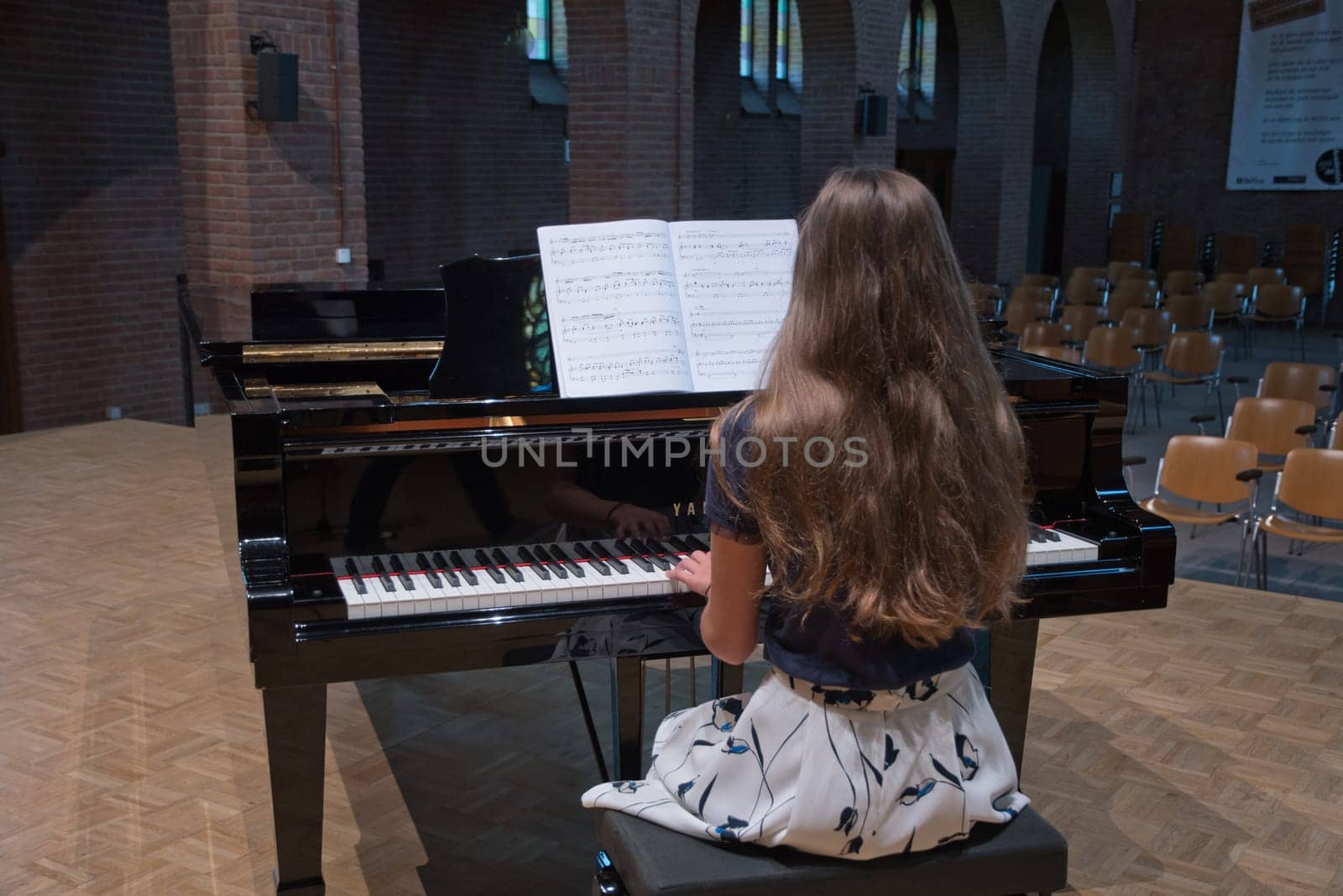 teenage girl playing the piano in the concert hall, hobby, music by KaterinaDalemans