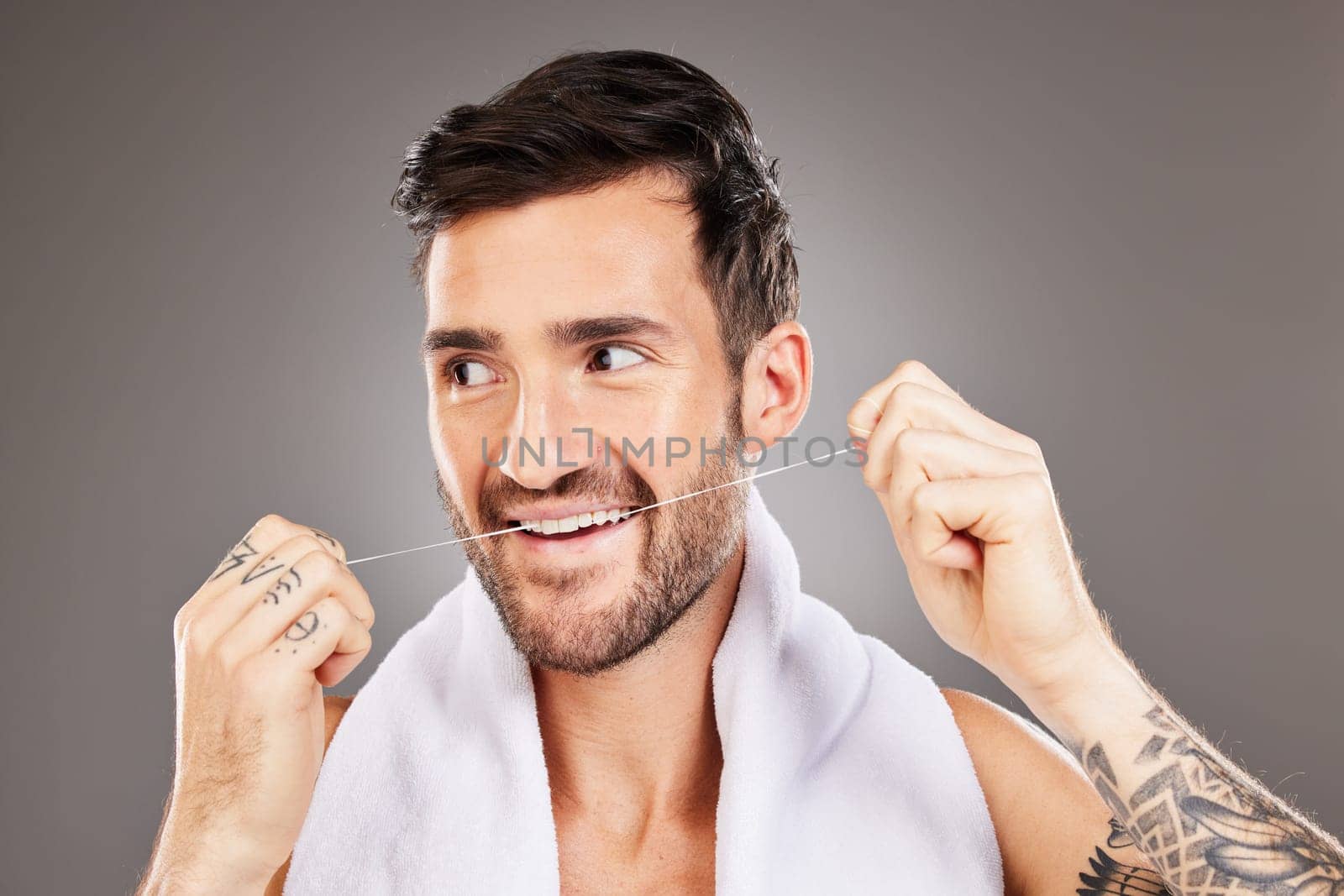 Teeth, dental floss and cleaning man in studio isolated on gray background. Oral care, dental health and happy male model from Australia tooth flossing for gum care, wellness or healthy mouth hygiene.
