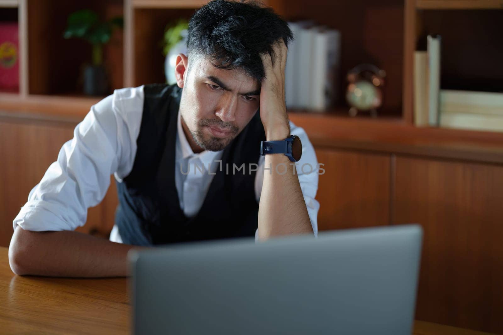 Portrait of an Asian man to be bored from working on a computer.