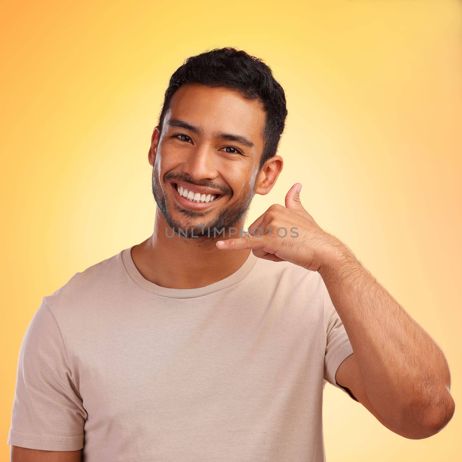 Portrait, call me hands and man in studio isolated on a yellow background. Face, fashion and happy male model with cool hand gesture for shaka sign, symbol or emoji for communication and connection. by YuriArcurs