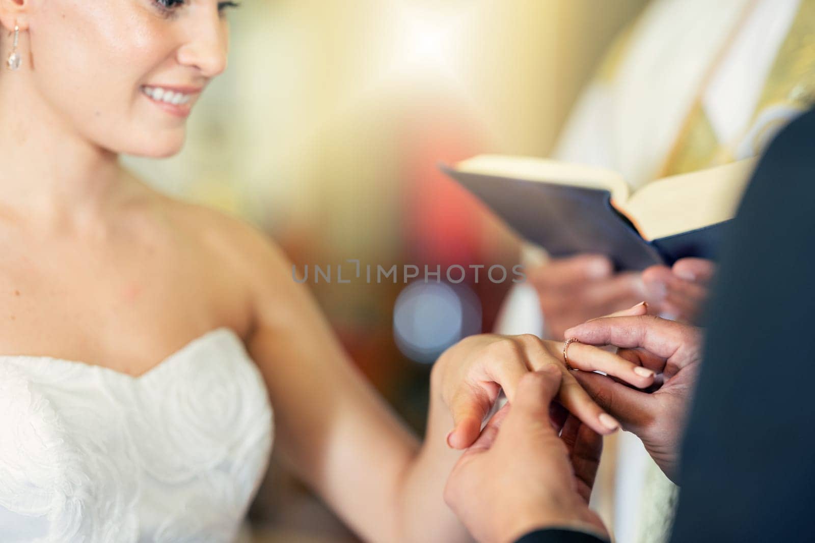 Wedding, marriage and putting ring on finger of bride in celebration of love, romance and commitment. Young couple getting married in church with groom giving jewellery to wife in wedding ceremony.
