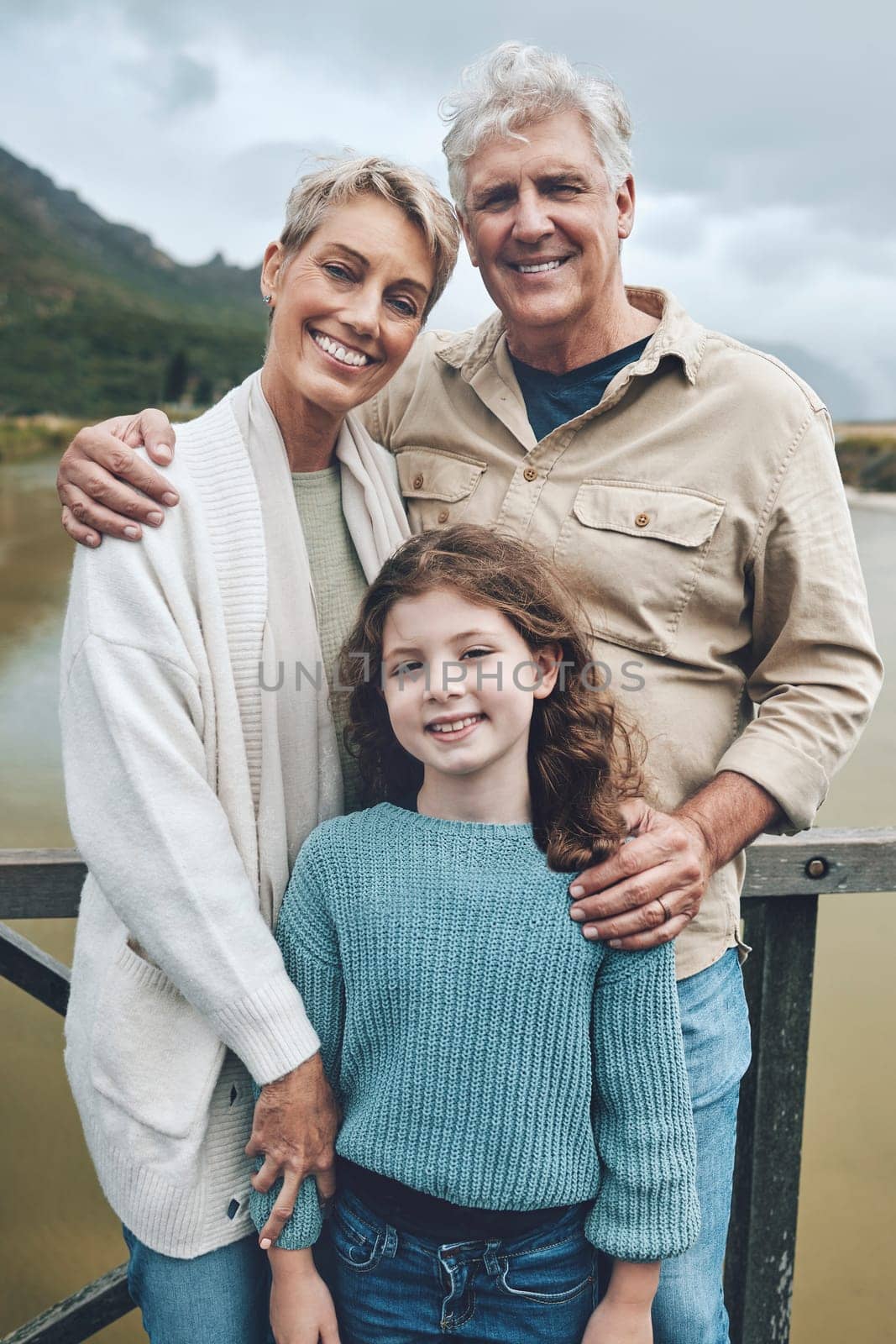 Family, grandparents and child being happy, bonding and vacation with smile, holiday or together outdoor. Portrait, grandfather and grandmother with girl to relax, embrace and on road trip for travel by YuriArcurs