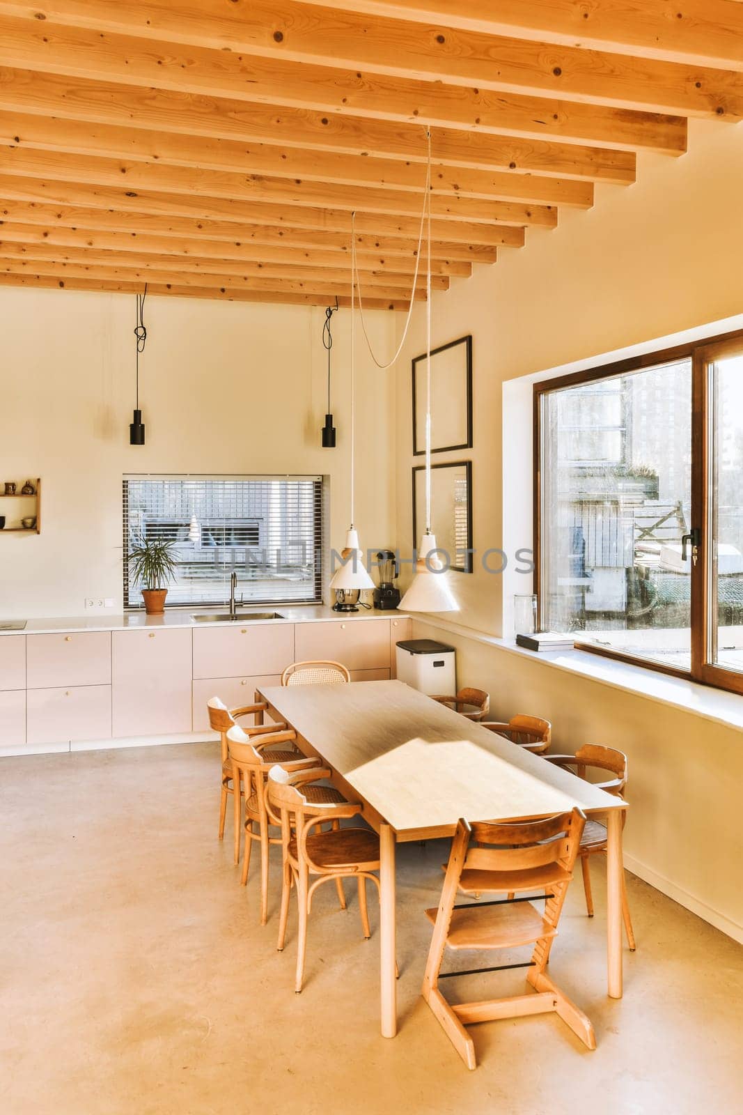 a kitchen and dining area in a house with wood beams on the ceiling, wooden table and chairs around it