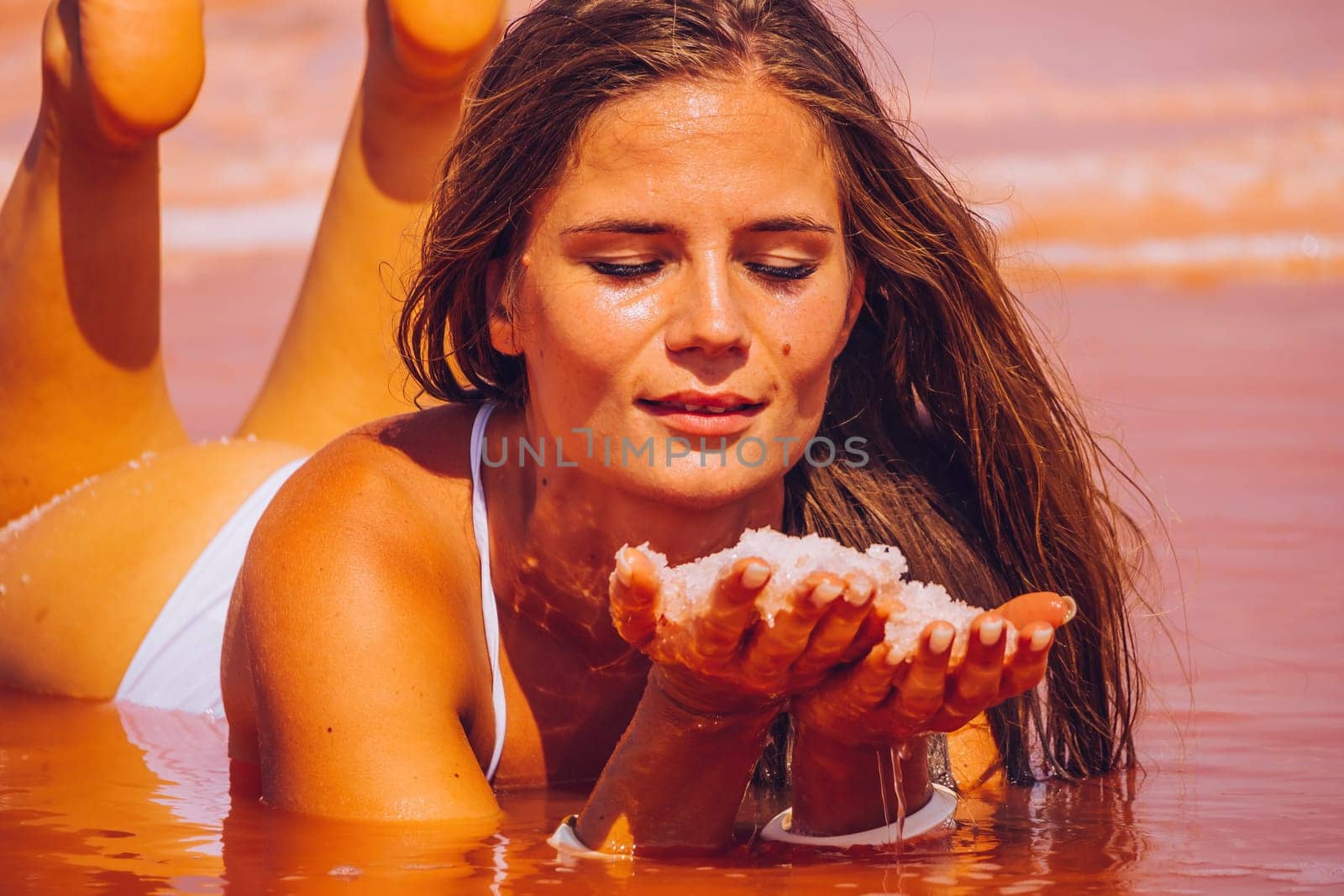 Salt mining. Salty pink lake with crystals of salt. Extremely salty pink lake, colored by microalgae with crystalline salt depositions