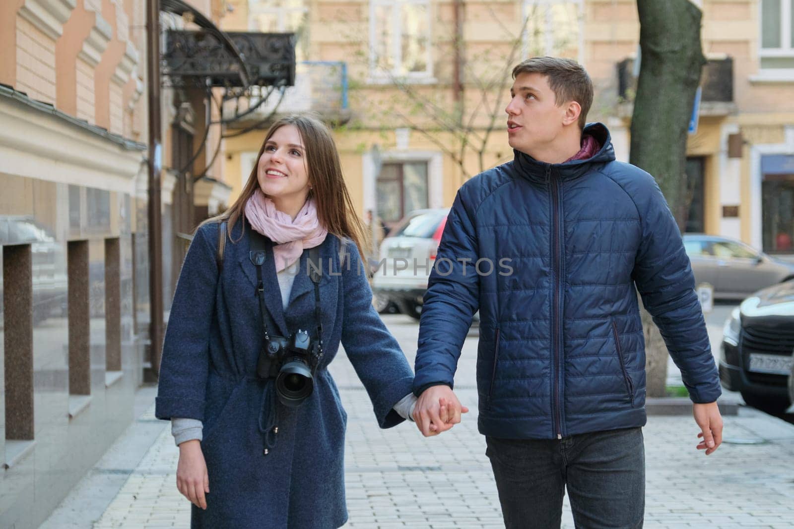 Young positive couple of young men and women blogger in city with camera. by VH-studio