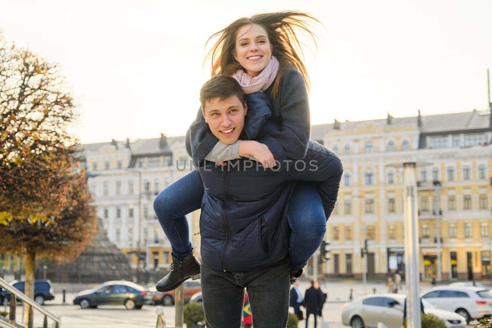 Youth having fun in spring city, beautiful funny young man and woman, golden hour by VH-studio