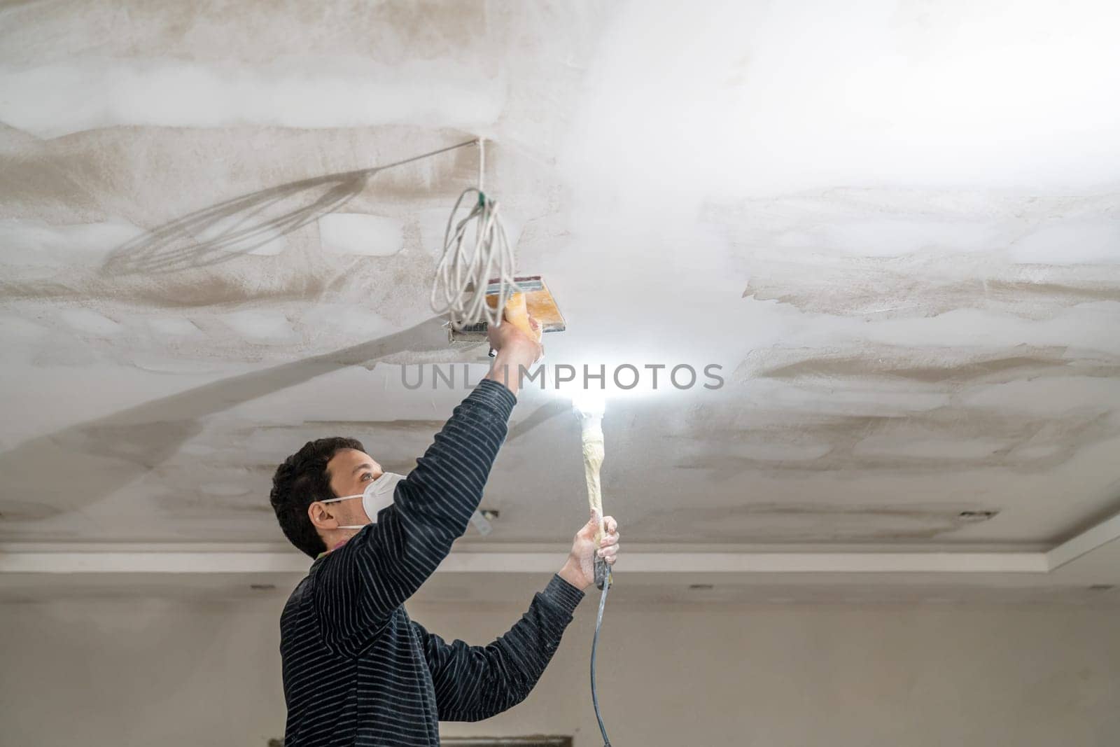 hand sanding of the plasterboard ceiling with a trowel.